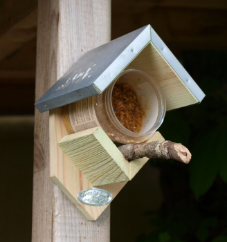 Vogelfutterhaus für Erdnussbuttergläser. Vogelfutterhaus für Futtergläser. Das Haus ist aus Kiefernholz mit einem Dach aus verzinktem Blech. Maße ca.: B 13 x T 12,5 x H 19 cm. Material: 100% FSC zertifiziertes Holz, Zink.